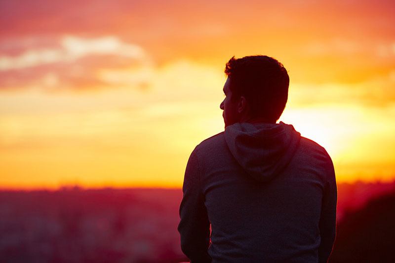 Rückansicht des Mannes gegenüber Sonnenuntergang