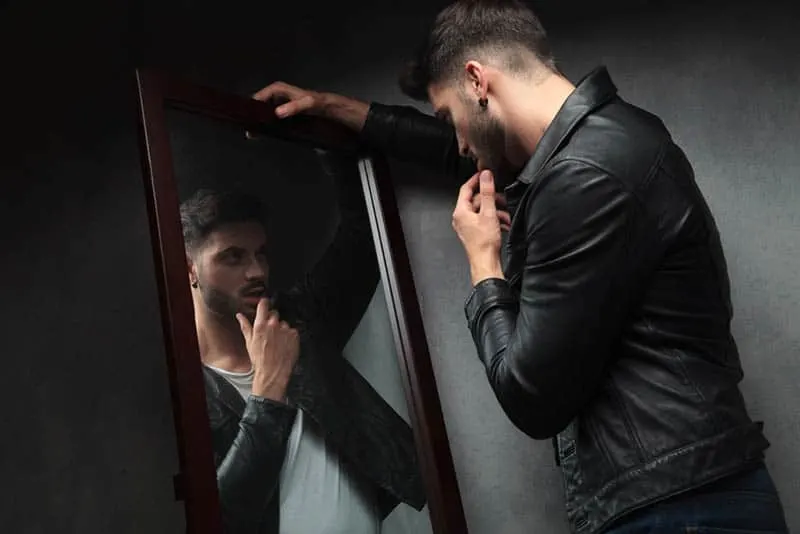 Mann, der sich in den Spiegel schaut