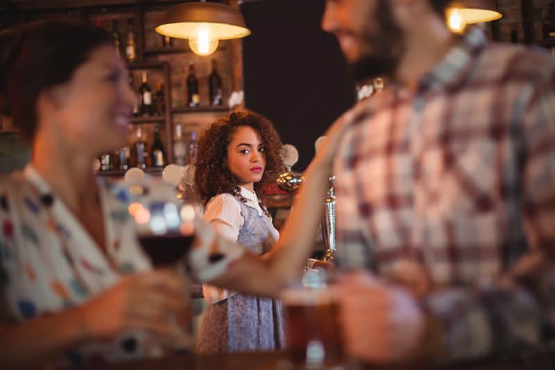 eifersüchtige Frau, die Paar an der Bar betrachtet