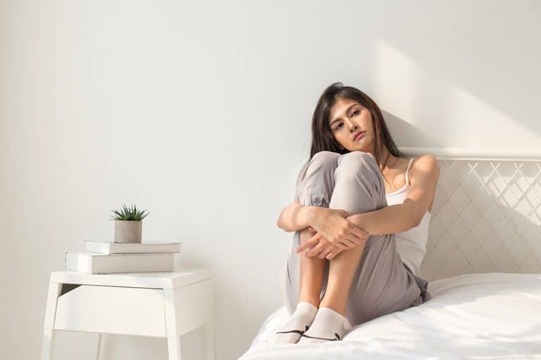 ein einsames Mädchen sitzt auf dem Bett