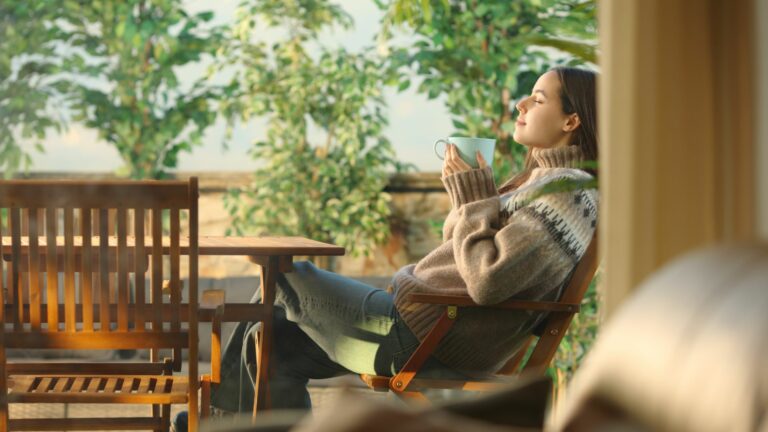 schoenes Maedchen trinkt Kaffee auf der Terrasse
