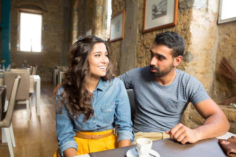 Junges Paar, das im Restaurant und im Café spricht