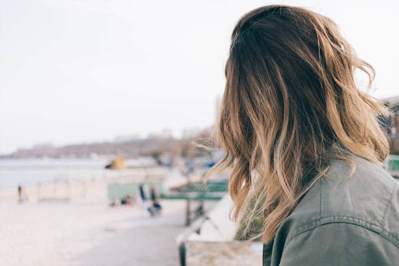 Rückansicht der blonden Frau vor dem Wasser