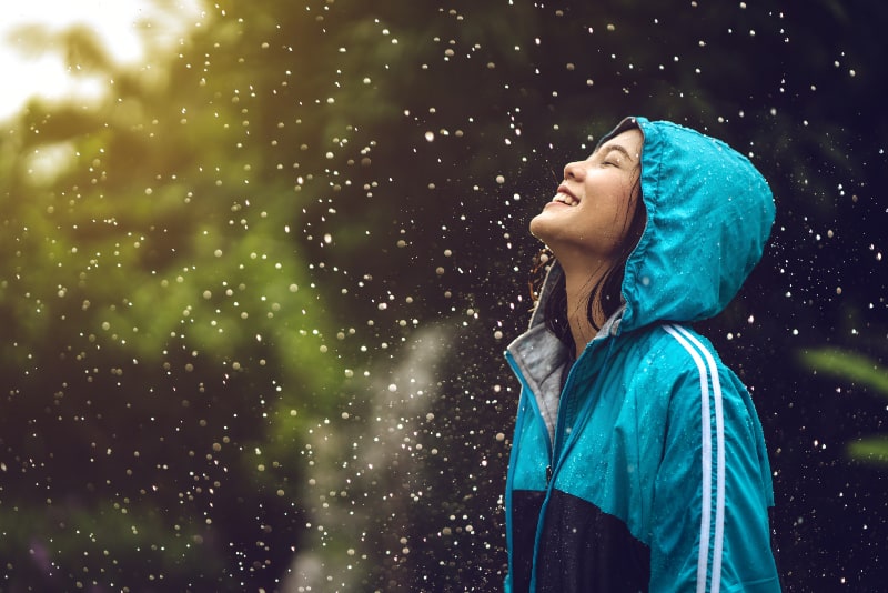 ein Mädchen, das im Regen einen Regenmantel trägt