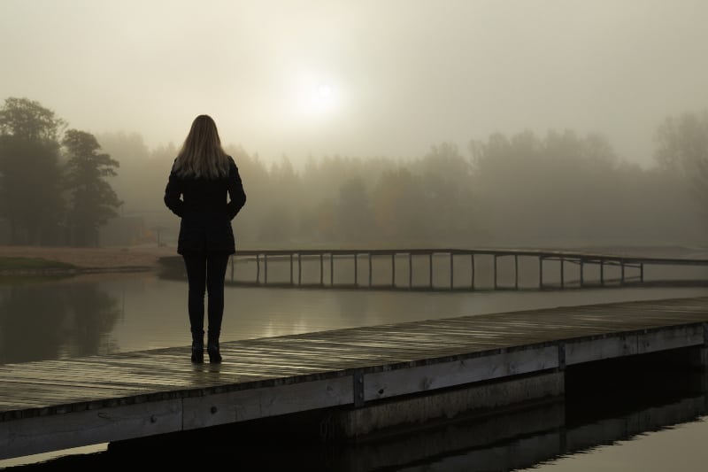 eine junge Frau allein am See