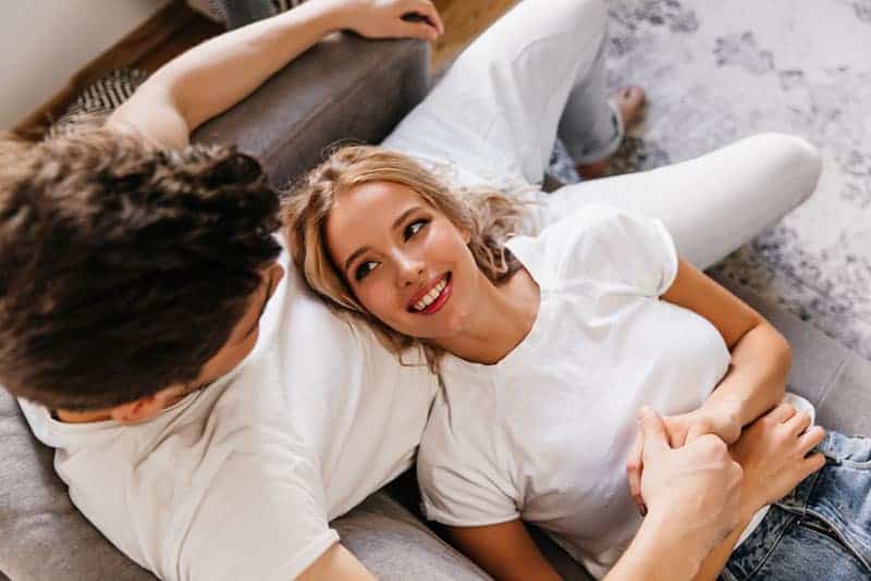 süße Frau auf Mann Schoß liegen