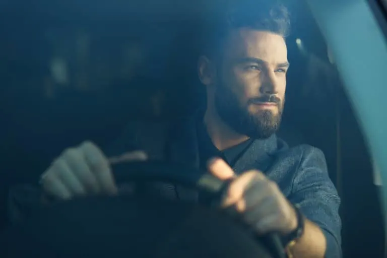 Ein Mann mit Bart fährt Auto