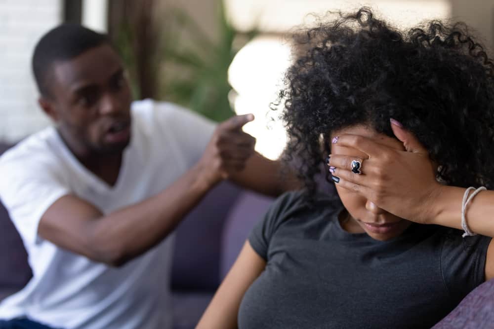 Ein schwarzer Mann bedroht seine traurige Frau