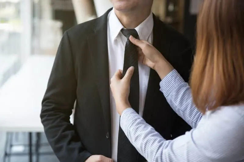 Eine Frau bindet eine Krawatte an ihren Mann