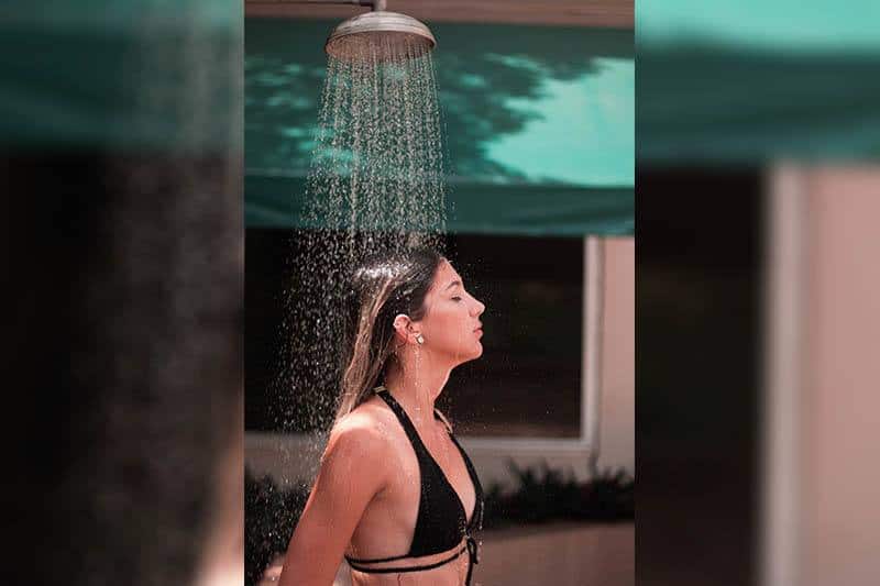 Eine Frau im Bikini genießt die Dusche