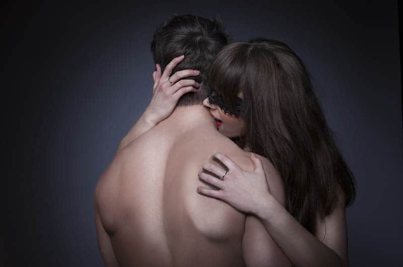 Beim Sex beißt eine Frau einem Mann in den Nacken