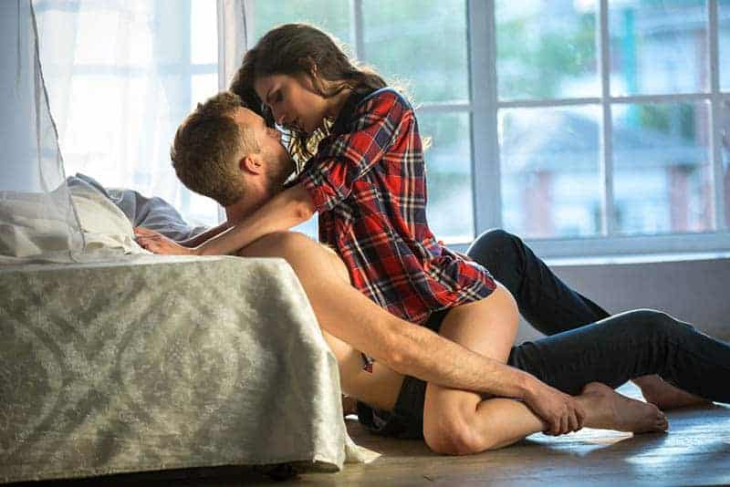Ein Mann und eine Frau auf dem Boden haben leidenschaftlichen Sex
