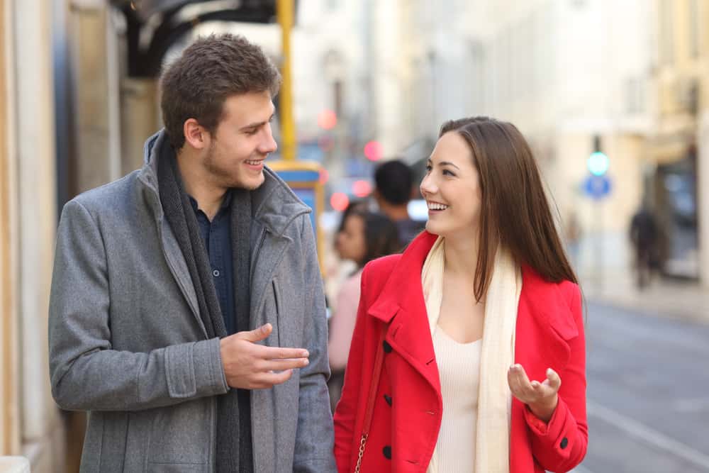 Ein Mann und eine Frau gehen die Straße entlang und unterhalten sich