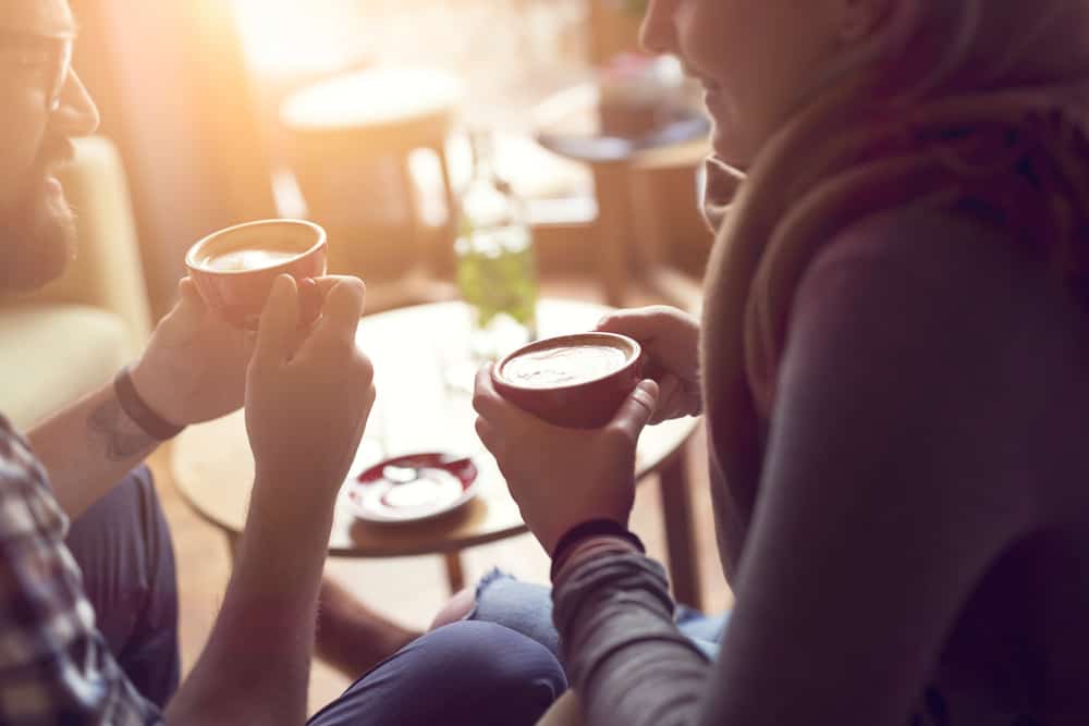 Ein junges Paar sitzt in einem Café und trinkt Kaffee
