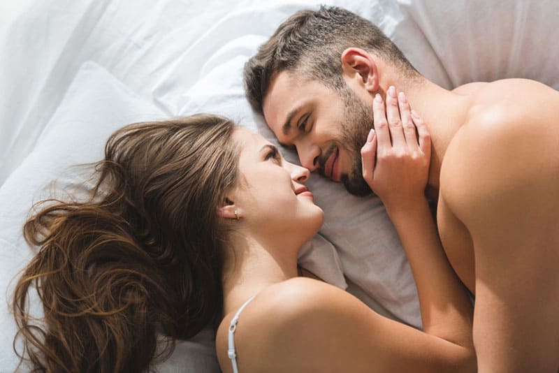 Frau kuschelt mit Mann im Bett