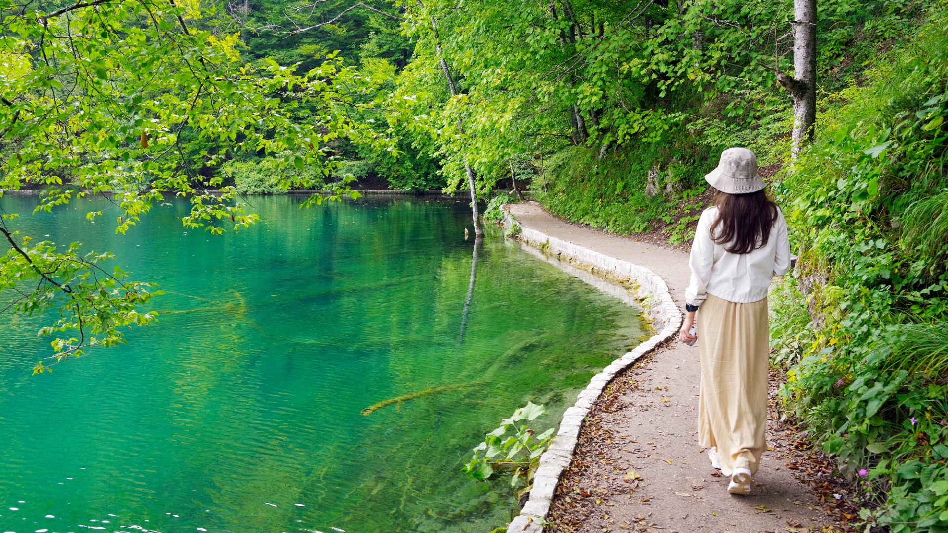 Frau geht in der Naehe von Wasser