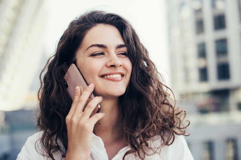 glückliche Frau, die am Telefon spricht