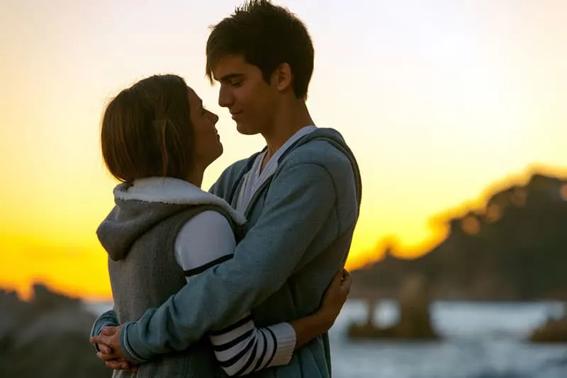 junges Paar, das bei Sonnenuntergang umarmt