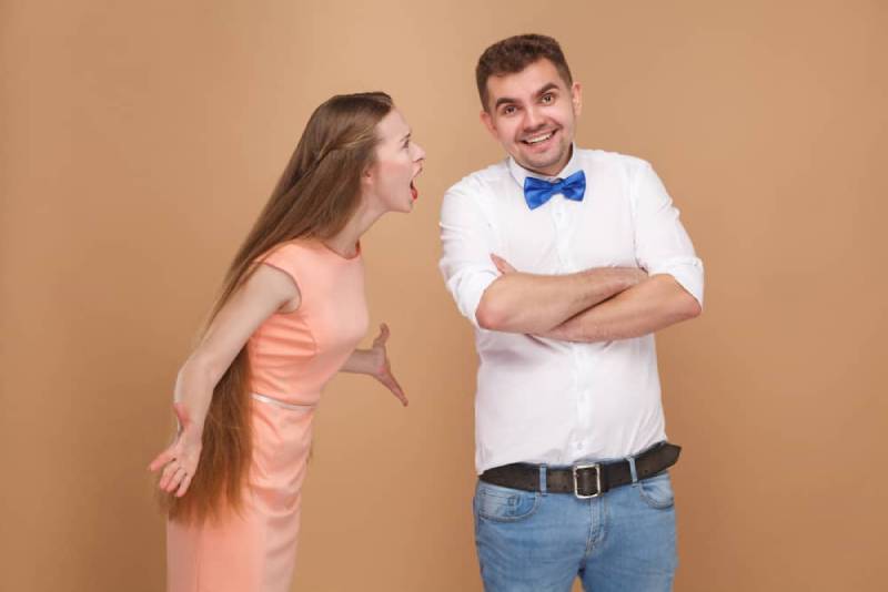 Der lächelnde Mann ignoriert seine wütende Frau