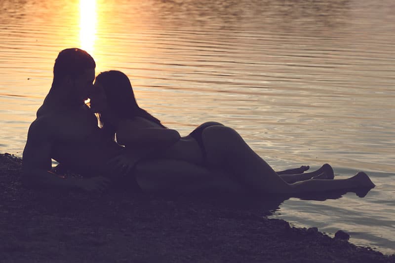 Sex eines Mannes und einer Frau bei Sonnenuntergang am Strand