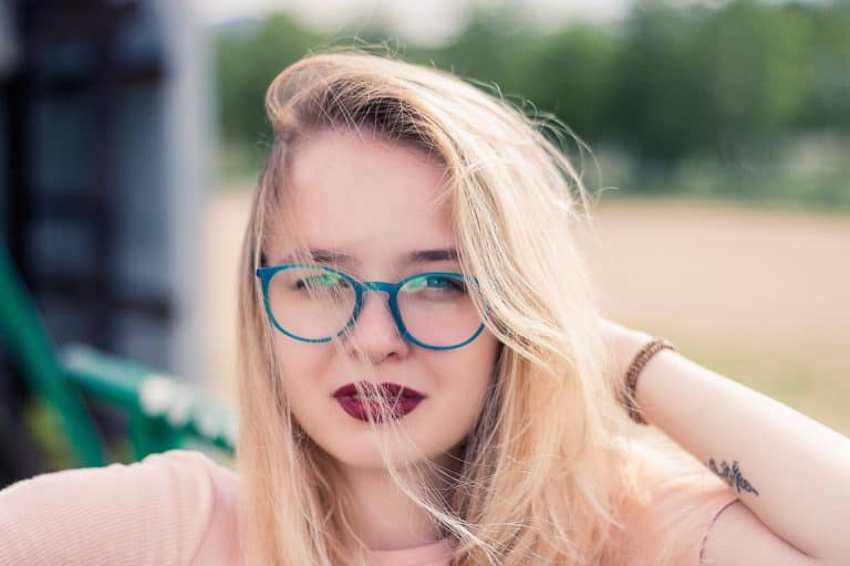 ein Mädchen in einem rosa T-Shirt mit Brille