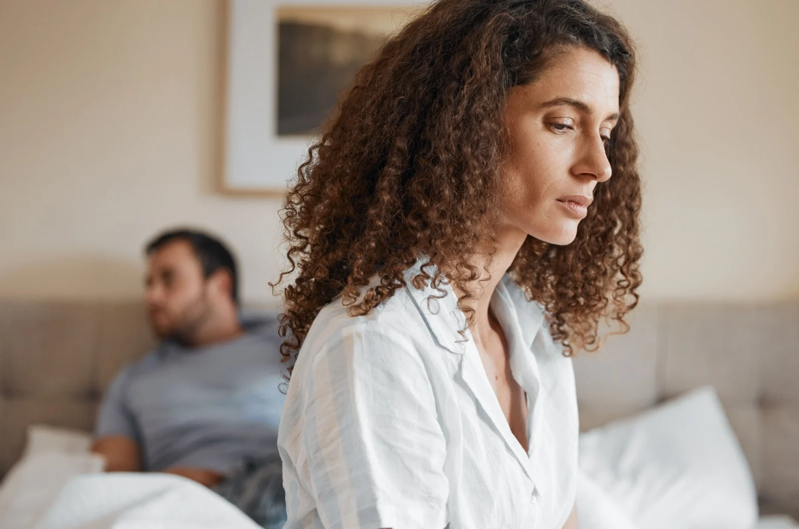traurige Frau sitzt auf dem Bett