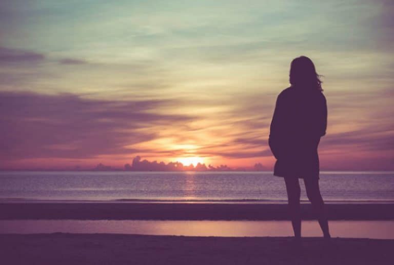ein Mädchen beobachtet den Sonnenuntergang