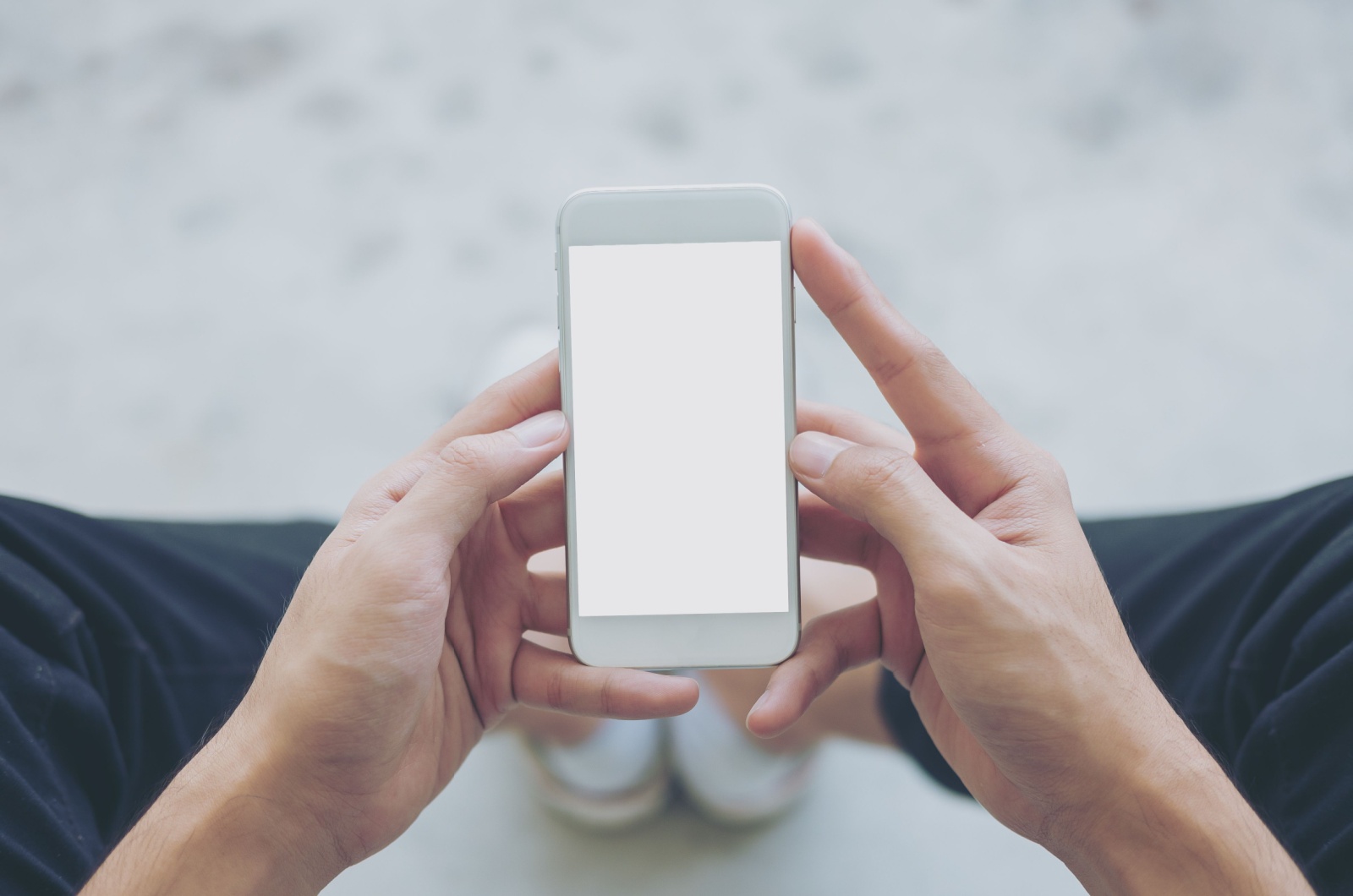 Mann haelt ein weisses Telefon