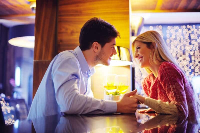 Paar, das sich beim Händchenhalten im Café ansieht