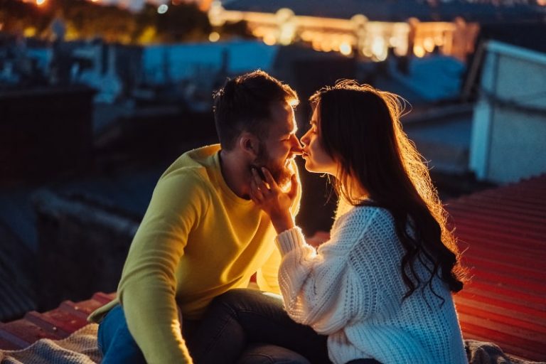 Abends sitzen ein Mann und eine Frau draußen und kuscheln