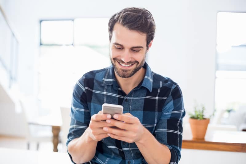 Ein Mann, der eine Nachricht über ein Handy sendet