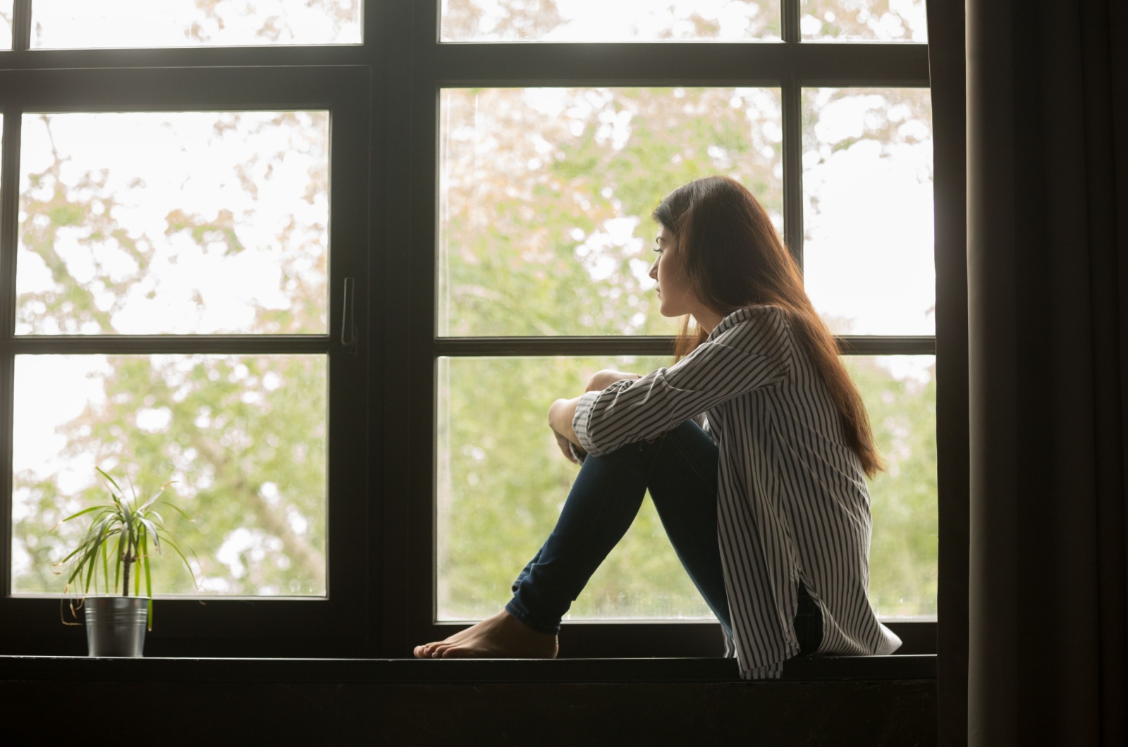 Frau schaut durch das Fenster