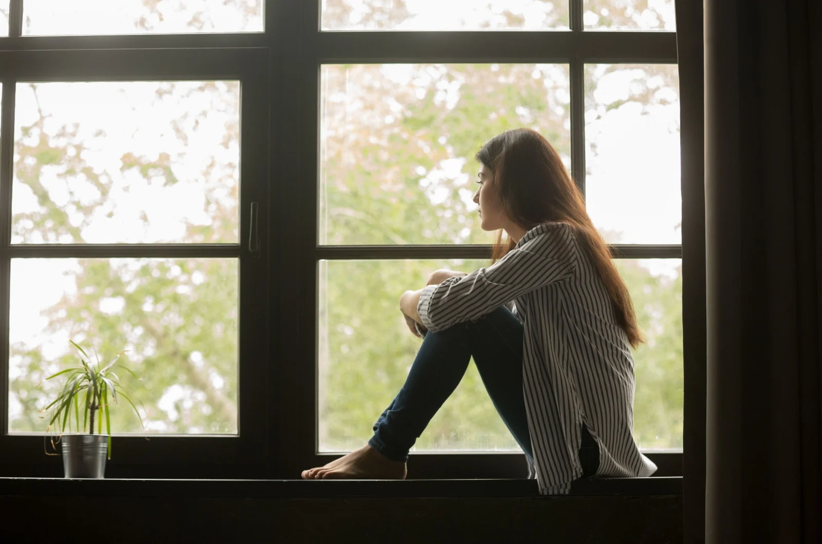 Frau schaut durch das Fenster