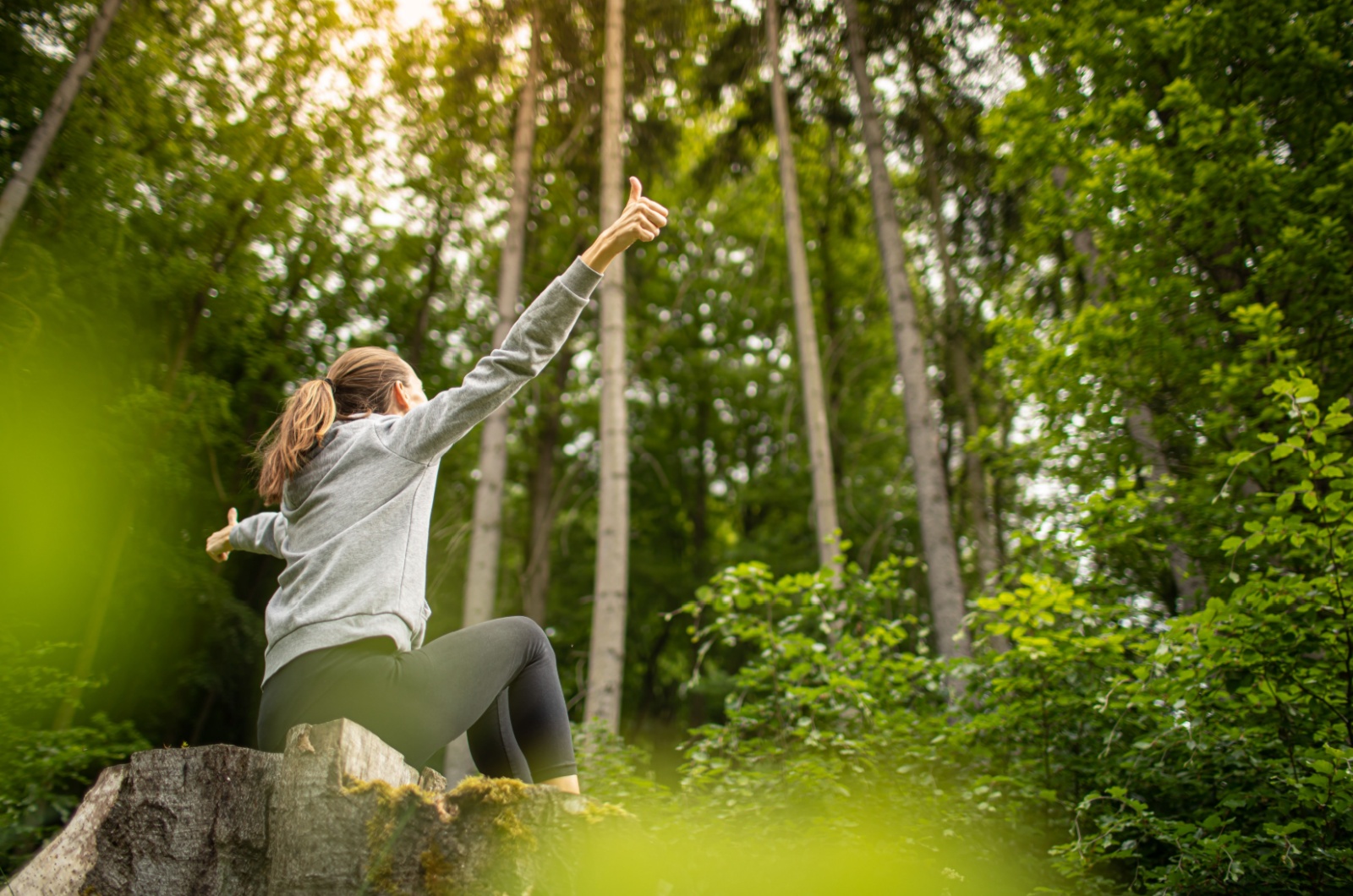 Frau sitzt im Wald