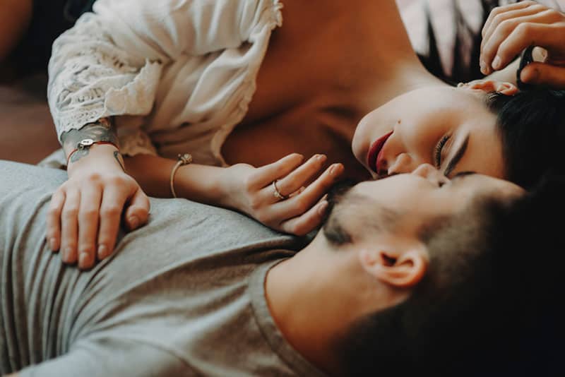 süßes Paar küssen und umarmen im Bett