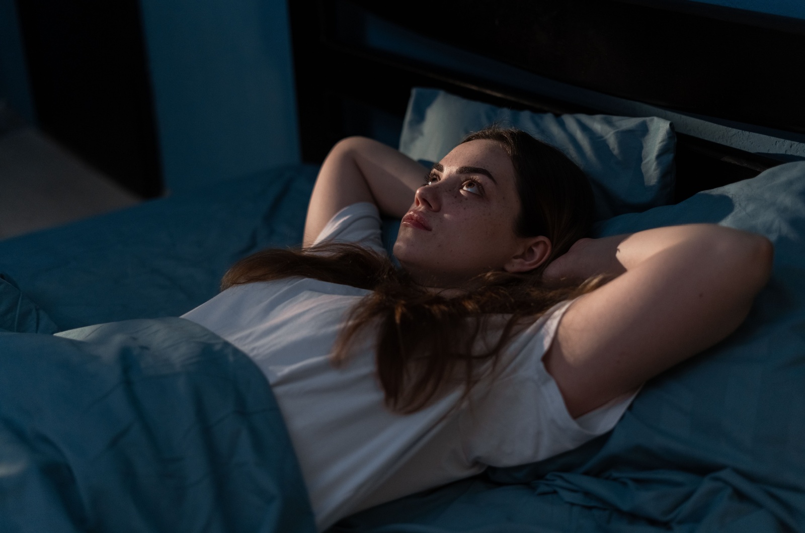 Frau im Bett denkend