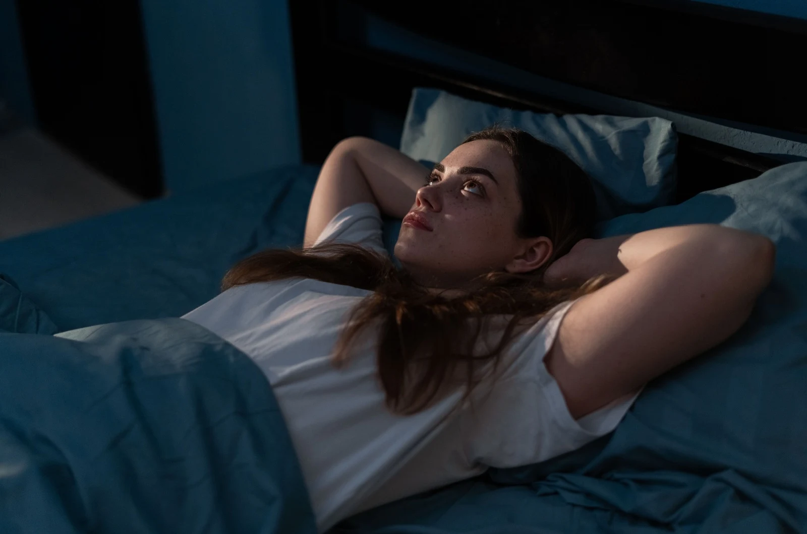 Frau im Bett denkend