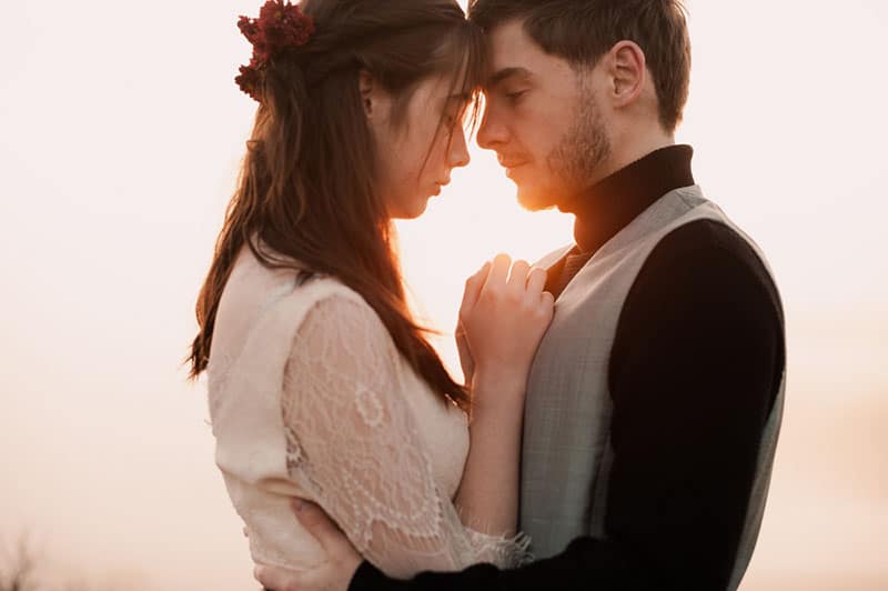 schönes und leidenschaftliches Paar umarmen und küssen im Sonnenuntergang