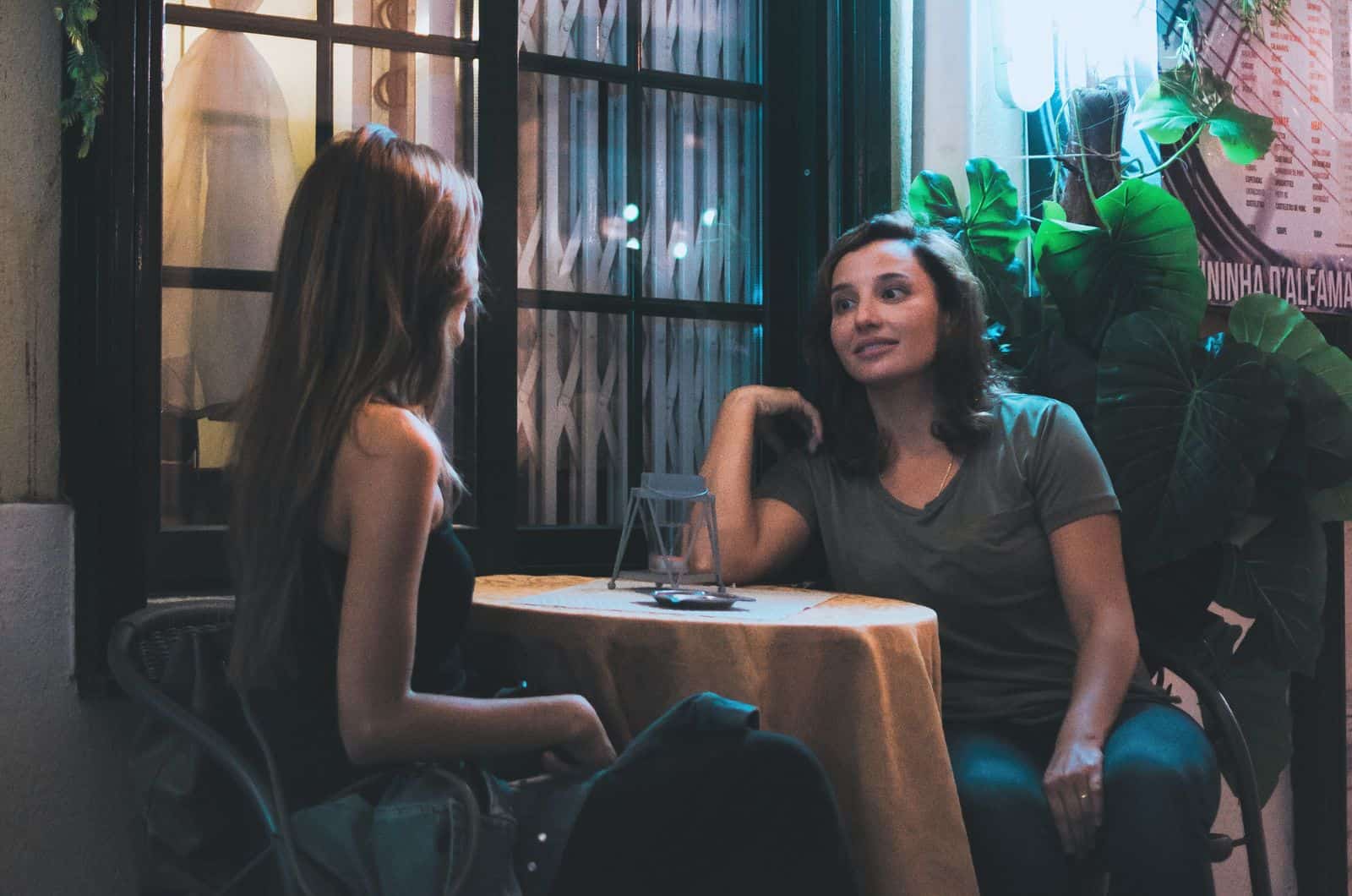 zwei Frauen sprechen im Café am Tisch sitzen
