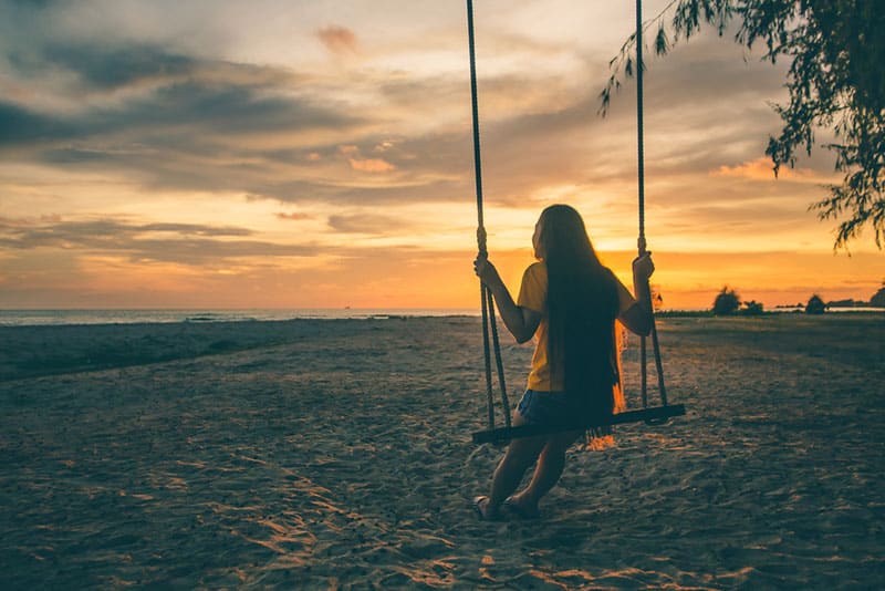 Frau am Strand draußen bei Sonnenuntergang