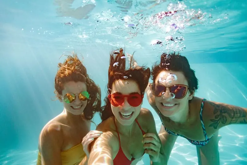 Freunde tauchen im Pool und machen ein Selfie