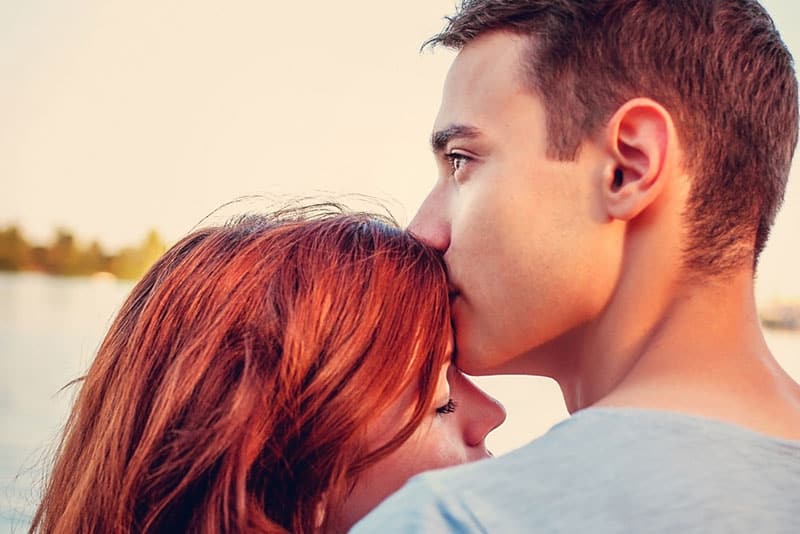 Männer küssen ein Mädchen in die Stirn