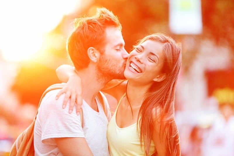 Mann küsste seine lächelnde Freundin draußen