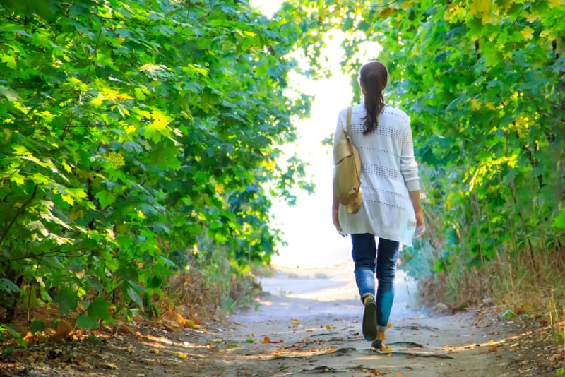 Mädchen geht den Weg im Wald entlang