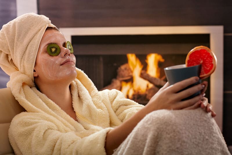 Mädchen sitzt mit Maske auf ihrem Gesicht und kühlt