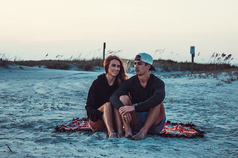 glückliches Paar beim Picknick am Strand