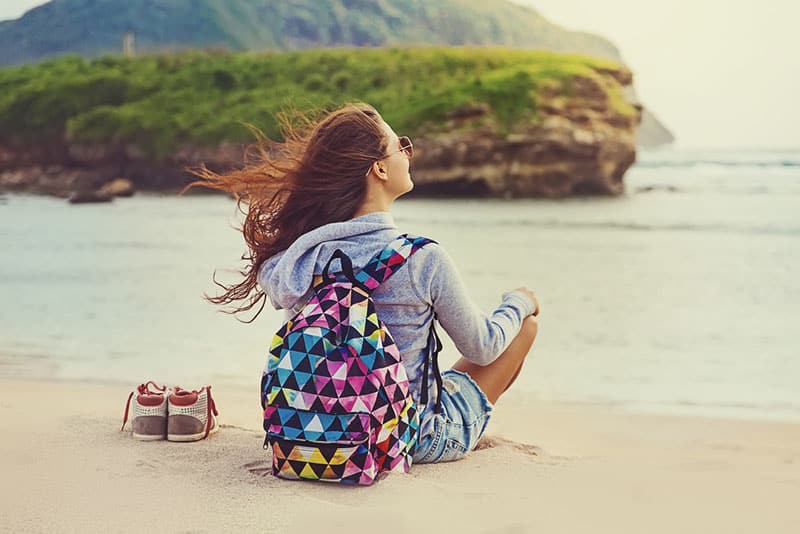 glückliche Frau, die am Strand sitzt