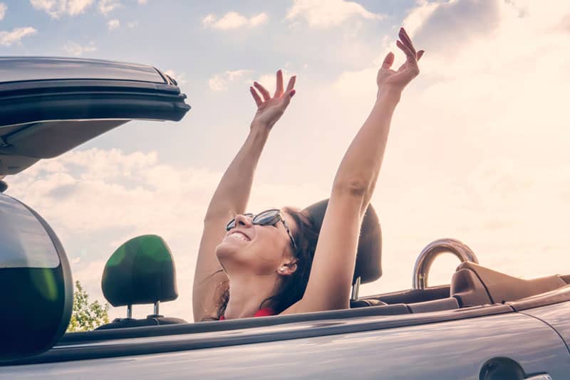 glückliche Frau im Auto lächelnd