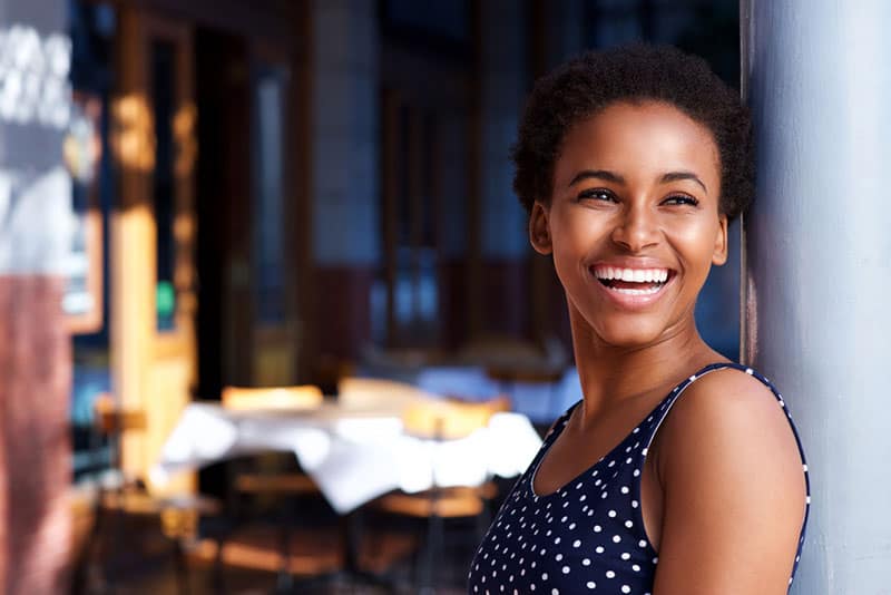 lächelnde Afro-Frau, die an der Tür steht