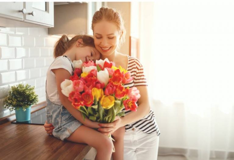 Kind Tochter gratuliert Mutter und gibt Tulpen einen Blumenstrauß